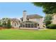 Back exterior view of house showcasing the large manicured lawn and screened porch at 335 Scarborough Way, Alpharetta, GA 30022