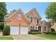 Well-maintained brick home with a two-car garage, neat landscaping, and a spacious driveway at 335 Scarborough Way, Alpharetta, GA 30022