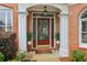 Inviting front entrance with a wood door, decorative plants, and stylish outdoor lighting at 335 Scarborough Way, Alpharetta, GA 30022