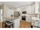 Kitchen with stainless steel appliances, granite countertops, white cabinets, and an island with seating at 335 Scarborough Way, Alpharetta, GA 30022