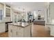 Kitchen featuring a large island, stainless steel appliances and seamless flow to the living room at 335 Scarborough Way, Alpharetta, GA 30022