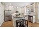 Well-lit kitchen featuring stainless steel appliances, granite countertops, and a kitchen island with seating at 335 Scarborough Way, Alpharetta, GA 30022