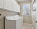 Bright laundry room featuring white cabinets and appliances, with ample space for chores at 335 Scarborough Way, Alpharetta, GA 30022