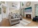 Open-concept living room with a fireplace, large TV, hardwood floors, and ample natural light at 335 Scarborough Way, Alpharetta, GA 30022