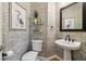Elegant powder room with pedestal sink, decorative wallpaper and a decorative mirror at 335 Scarborough Way, Alpharetta, GA 30022