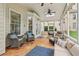 A cozy sunroom featuring tile floors, ceiling fans, comfortable seating, and abundant natural light at 335 Scarborough Way, Alpharetta, GA 30022