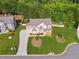 Aerial view of a beautifully landscaped home featuring a manicured lawn and mature trees at 4090 Sierra Knolls Ct, Cumming, GA 30040