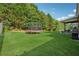 Large backyard with green grass and a trampoline and outdoor grill at 4090 Sierra Knolls Ct, Cumming, GA 30040