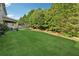 Expansive backyard featuring lush green grass and privacy trees at 4090 Sierra Knolls Ct, Cumming, GA 30040