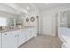 Modern bathroom featuring dual sinks, white cabinets, a glass shower, and a soaking tub at 4090 Sierra Knolls Ct, Cumming, GA 30040