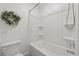 Clean, white bathroom with a tub and shower featuring built-in shelves at 4090 Sierra Knolls Ct, Cumming, GA 30040