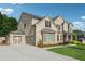 Elegant brick home with a three-car garage and a beautifully landscaped front yard at 4090 Sierra Knolls Ct, Cumming, GA 30040