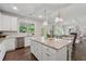 Open concept kitchen and living area with white cabinets, granite counters, and an island at 4090 Sierra Knolls Ct, Cumming, GA 30040