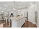 Open layout shows the kitchen island, stainless appliances and view to the living area at 4090 Sierra Knolls Ct, Cumming, GA 30040