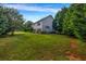 Spacious backyard featuring manicured lawn and bordered by mature trees, offering a private outdoor space at 15 Saddlebrook Ct, Covington, GA 30016