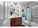 Bathroom featuring wood cabinet, sink, and toilet, complemented by an accent mirror and light fixture at 15 Saddlebrook Ct, Covington, GA 30016