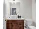 Elegant half bathroom features a wood vanity, vessel sink, and modern fixtures at 15 Saddlebrook Ct, Covington, GA 30016
