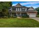 Charming two-story home with a well-manicured lawn, inviting front porch, and attached two-car garage at 15 Saddlebrook Ct, Covington, GA 30016