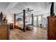 Grand main bedroom showcases a four-poster bed, ceiling fan, and hardwood floors, creating a luxurious retreat at 15 Saddlebrook Ct, Covington, GA 30016