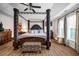 Luxurious main bedroom featuring a four-poster bed, hardwood floors, and elegant furnishings at 15 Saddlebrook Ct, Covington, GA 30016