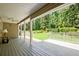 Spacious covered back porch with wood flooring overlooking a lush green backyard at 3440 Wilson Rd, South Fulton, GA 30349