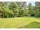 Expansive backyard features a large lawn surrounded by mature trees, offering privacy and space at 3440 Wilson Rd, South Fulton, GA 30349