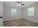 A sunlit bedroom features wood floors, ceiling fan, and two windows for natural light at 3440 Wilson Rd, South Fulton, GA 30349