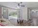 A bright living room featuring wood floors, ceiling fan, and sliding door to screened patio at 3440 Wilson Rd, South Fulton, GA 30349