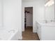 This bathroom features marble countertops, white cabinets, and wood-grain floors at 5050 Brownwood Dr, Powder Springs, GA 30127