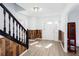 Bright foyer with wood-look flooring, accent wall paneling, and an open staircase at 5050 Brownwood Dr, Powder Springs, GA 30127