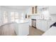 Bright kitchen features white cabinets, stainless appliances, an island, and large windows overlooking the yard at 5050 Brownwood Dr, Powder Springs, GA 30127