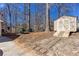 Image of a backyard shed with double doors and a ramp, surrounded by trees and foliage, on a sunny day at 5050 Brownwood Dr, Powder Springs, GA 30127