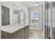 Bright bathroom featuring a gray double vanity, modern fixtures, white countertops, and a glass enclosed shower at 102 Grand Cres, Alpharetta, GA 30009