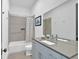 Well-lit bathroom with double sink vanity, shower-tub combo and modern finishes at 102 Grand Cres, Alpharetta, GA 30009
