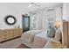 Inviting bedroom with large windows, neutral tones, and decorative sunburst mirror at 102 Grand Cres, Alpharetta, GA 30009
