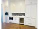 A well-appointed kitchen has integrated coffee maker, wine fridge, marble counters, and stainless appliances at 102 Grand Cres, Alpharetta, GA 30009