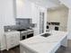 A modern kitchen is equipped with stainless steel appliances, a center island, and grey herringbone backsplash at 102 Grand Cres, Alpharetta, GA 30009