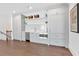 A charming kitchenette with shaker cabinets, stainless steel appliances, floating shelves, and white backsplash is well-lit at 102 Grand Cres, Alpharetta, GA 30009