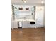 A charming kitchenette with shaker cabinets, stainless steel appliances, floating shelves, and white backsplash is well-lit at 102 Grand Cres, Alpharetta, GA 30009