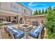 Elegant outdoor patio with a fire pit, grill, and seating, connecting to a modern interior at 102 Grand Cres, Alpharetta, GA 30009