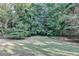 This backyard features mature trees offering shade and privacy at 1301 Dayspring Trce, Lawrenceville, GA 30045
