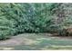 This backyard features mature trees offering shade and privacy at 1301 Dayspring Trce, Lawrenceville, GA 30045