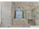 Bright bathroom with a jacuzzi tub, a glass enclosed shower, and tile flooring at 1301 Dayspring Trce, Lawrenceville, GA 30045