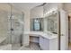 Bright bathroom features a vanity with double sinks and a glass enclosed shower at 1301 Dayspring Trce, Lawrenceville, GA 30045