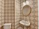 Powder room featuring pedestal sink, oval mirror, and unique geometric wallpaper at 1301 Dayspring Trce, Lawrenceville, GA 30045