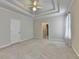 Large carpeted bedroom boasts a decorative trey ceiling and bright neutral tones at 1301 Dayspring Trce, Lawrenceville, GA 30045