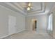 Large carpeted bedroom boasts a decorative trey ceiling and bright neutral tones at 1301 Dayspring Trce, Lawrenceville, GA 30045