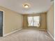 Simple bedroom with neutral walls, plush carpet, standard window, base trim, and overhead lighting at 1301 Dayspring Trce, Lawrenceville, GA 30045