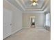 Large carpeted bedroom boasts a decorative trey ceiling and bright neutral tones at 1301 Dayspring Trce, Lawrenceville, GA 30045