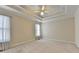 Spacious carpeted bedroom featuring a trey ceiling, ceiling fan, and natural light at 1301 Dayspring Trce, Lawrenceville, GA 30045